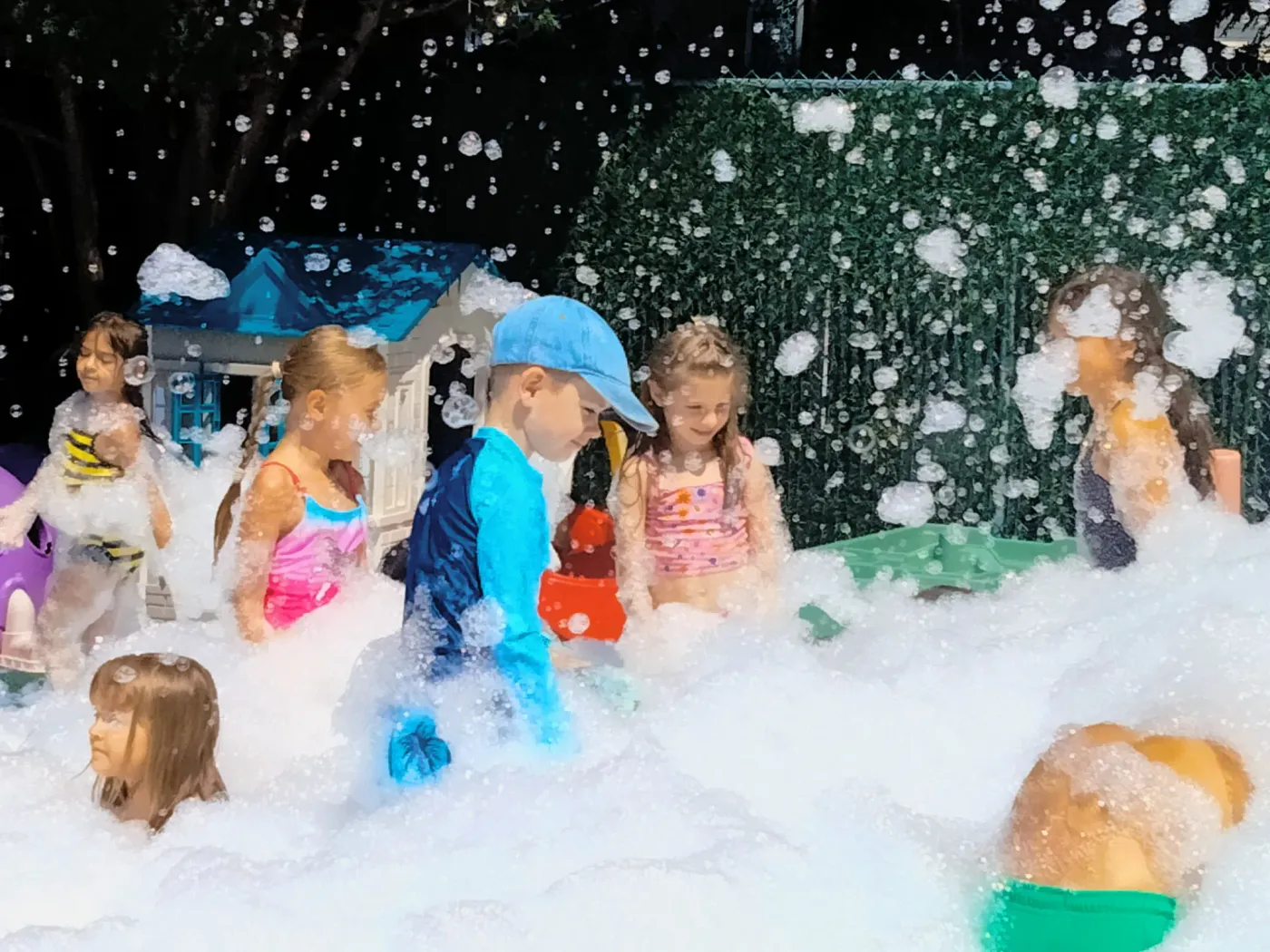 Children dancing together at a foam party